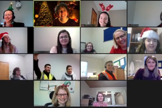A hosted Festive Family Feud session on Zoom with fourteen people in holiday hats